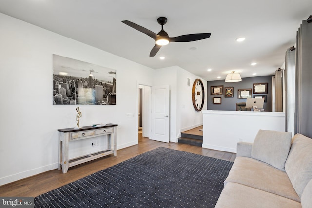 living room featuring dark wood-type flooring and ceiling fan