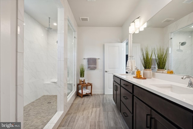 bathroom with vanity and tiled shower