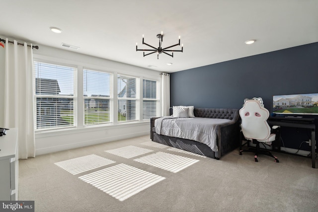 bedroom with an inviting chandelier and light colored carpet