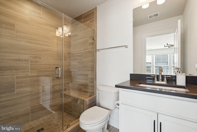 bathroom with toilet, a shower with shower door, and vanity