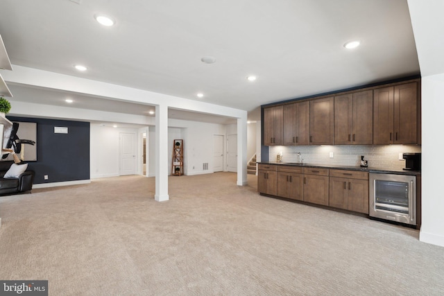 kitchen featuring sink, light carpet, tasteful backsplash, and beverage cooler