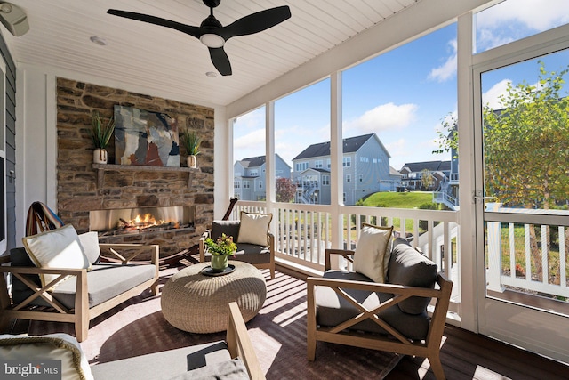 sunroom / solarium with wood ceiling, a healthy amount of sunlight, a fireplace, and ceiling fan