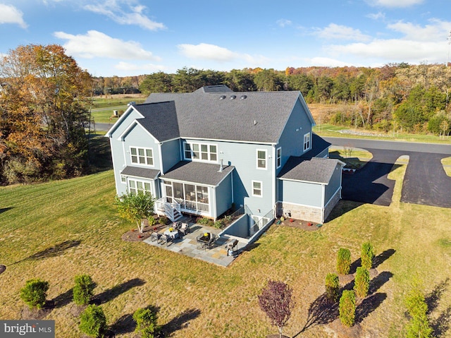 back of property featuring a patio area and a lawn