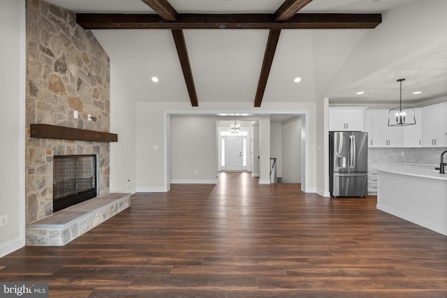 14628 Old Hanover Rd Regi, Unit Regi, Reisterstown, MD 21136 - unfurnished living room featuring baseboards, lofted ceiling with beams, a fireplace, and dark wood-type flooring