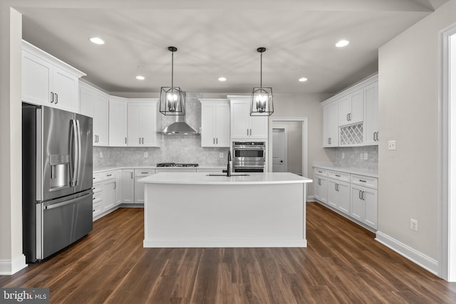 kitchen featuring dark wood-type flooring, white cabinetry, stainless steel appliances, and an island with sink