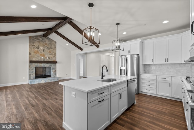 kitchen with sink, an island with sink, dark hardwood / wood-style floors, and white cabinetry