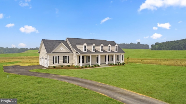 cape cod house with covered porch, a rural view, and a front lawn