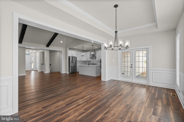 unfurnished living room with french doors, dark hardwood / wood-style floors, beamed ceiling, and sink