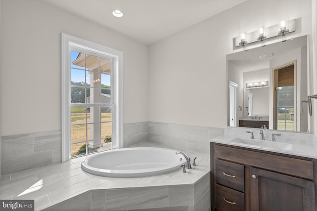 bathroom with vanity and a relaxing tiled tub