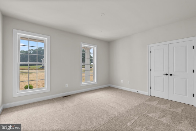 14628 Old Hanover Rd Regi, Unit Regi, Reisterstown, MD 21136 - unfurnished bedroom featuring multiple windows, a closet, baseboards, and carpet floors