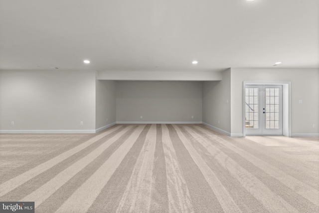 basement featuring light carpet and french doors