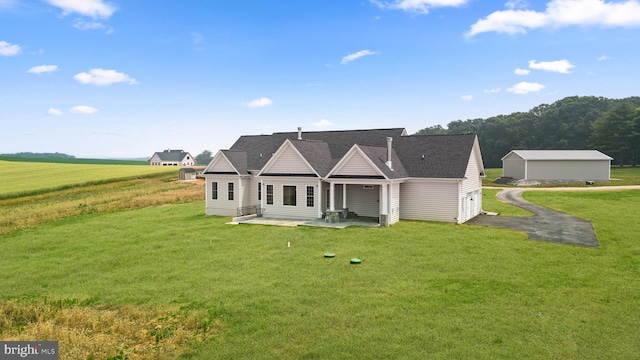 back of house featuring an outdoor structure and a lawn