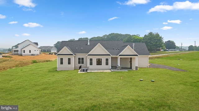 rear view of house featuring a patio and a lawn