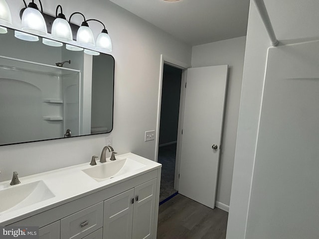 bathroom with a shower, vanity, and wood-type flooring