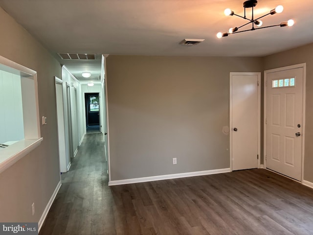 foyer with dark hardwood / wood-style floors and a notable chandelier