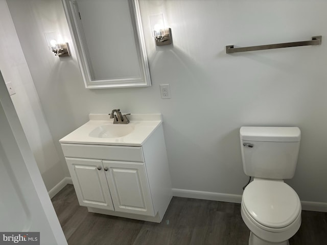 bathroom with hardwood / wood-style floors, vanity, and toilet