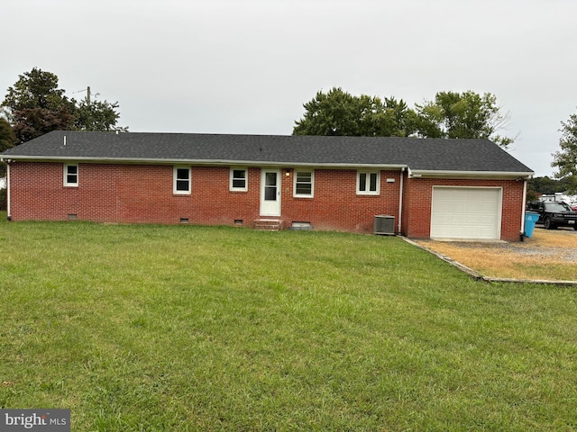 back of property with central AC unit, a garage, and a lawn