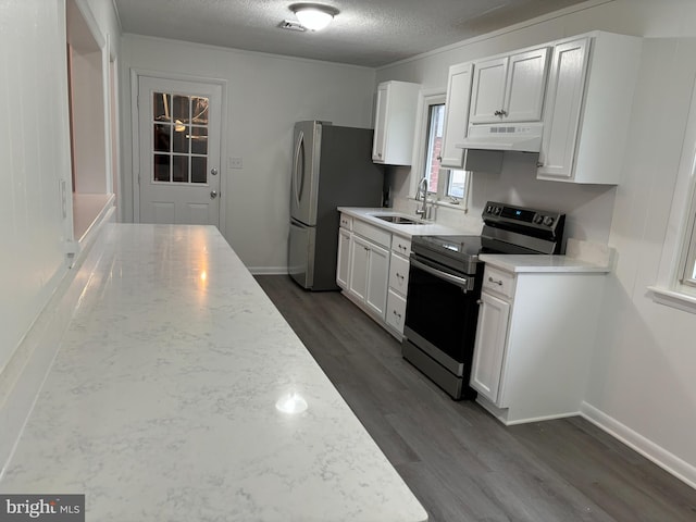 kitchen featuring light stone countertops, white cabinetry, sink, stainless steel appliances, and a textured ceiling