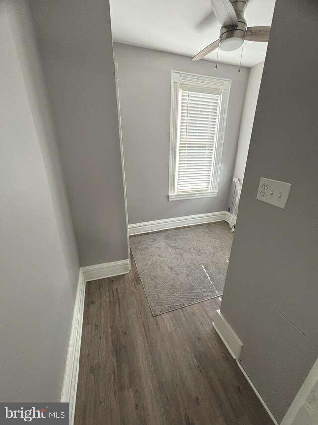 unfurnished room with ceiling fan and dark wood-type flooring