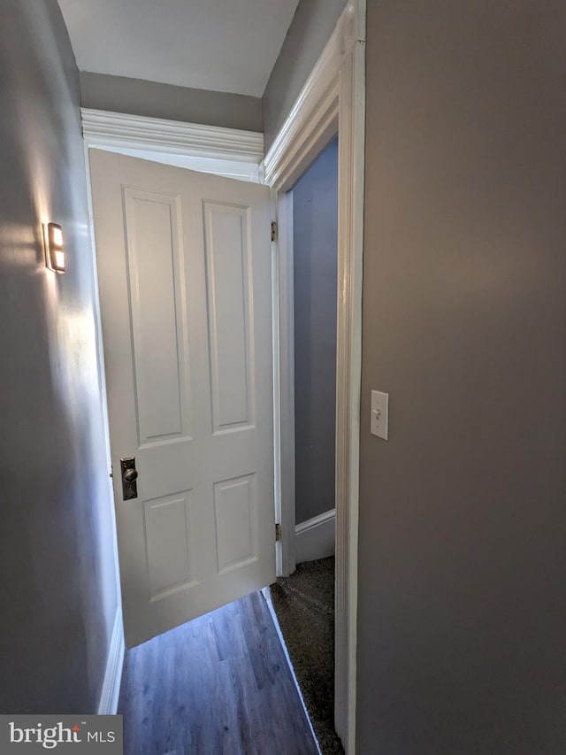 hallway with hardwood / wood-style flooring