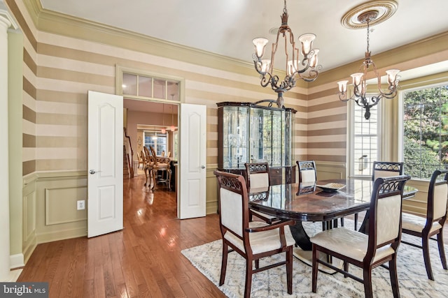 dining room with ornamental molding, a notable chandelier, and dark hardwood / wood-style floors