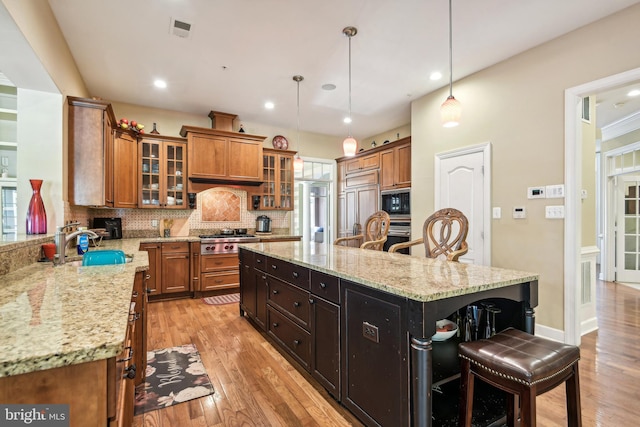 708 Church Rd S, Upper Marlboro, MD 20774 - kitchen with appliances with stainless steel finishes, a kitchen island, brown cabinets, and a sink