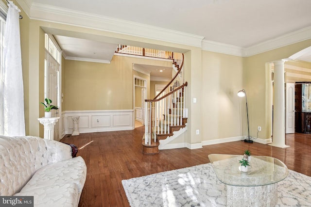 living room with dark wood-type flooring, ornamental molding, and decorative columns