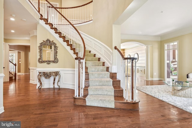 stairway featuring crown molding, hardwood / wood-style floors, and ornate columns