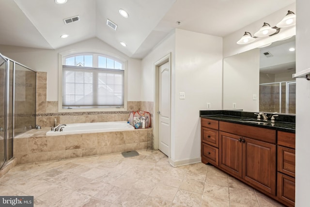 bathroom featuring vanity, independent shower and bath, and vaulted ceiling