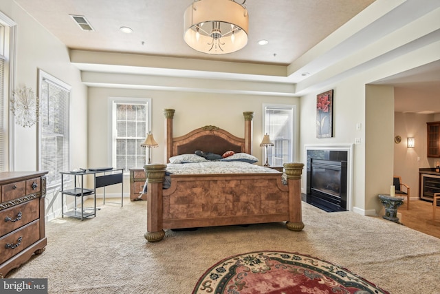 carpeted bedroom with a tile fireplace