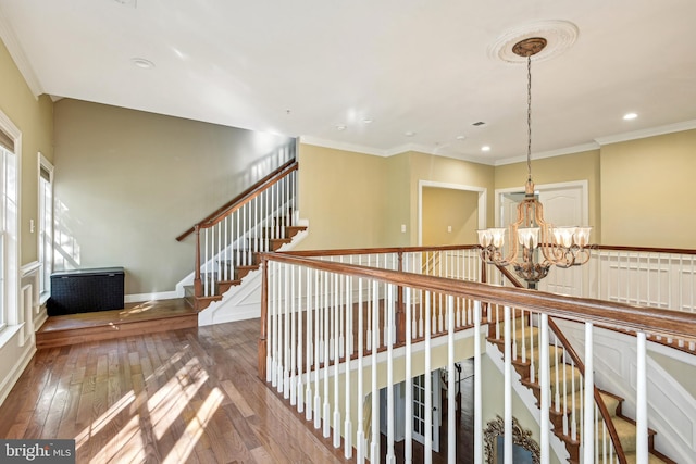 hall featuring crown molding, a notable chandelier, and dark hardwood / wood-style floors