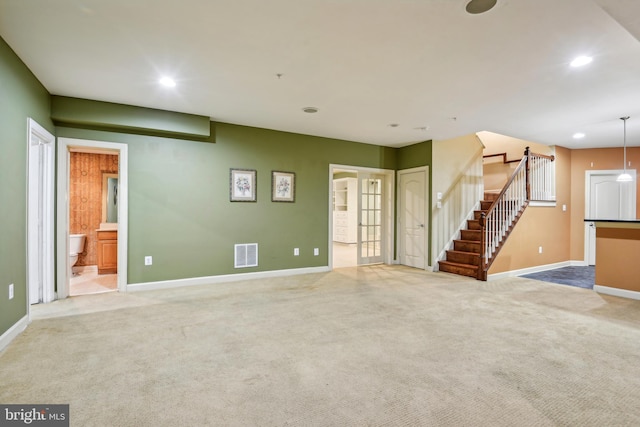 unfurnished living room with light colored carpet