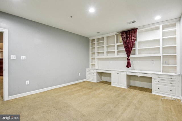 unfurnished office featuring light carpet and built in desk