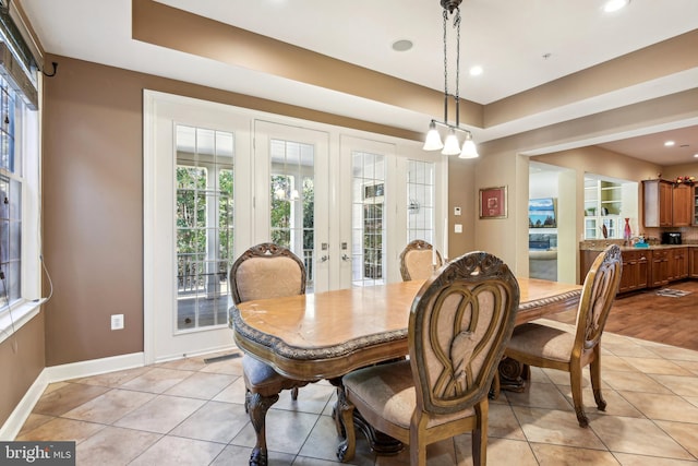 dining space with french doors, an inviting chandelier, and light tile patterned floors