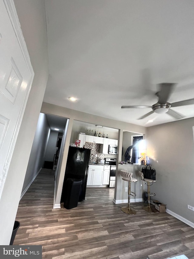 kitchen with white cabinets, stainless steel appliances, and dark hardwood / wood-style flooring