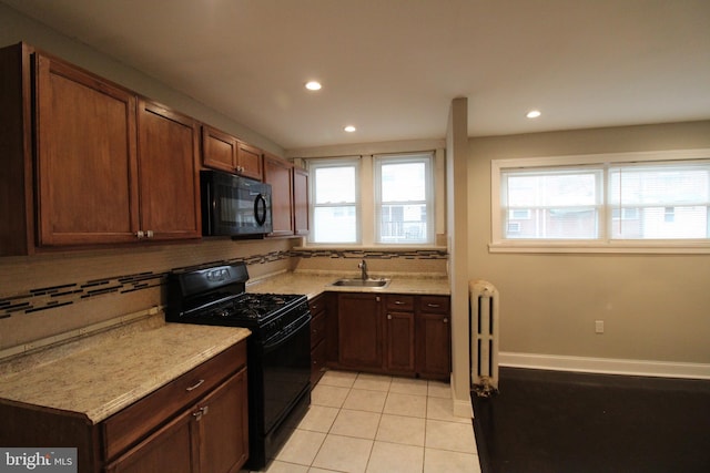 kitchen featuring decorative backsplash, sink, light tile patterned flooring, and black appliances