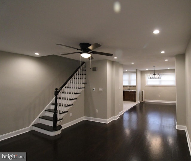 interior space with radiator, ceiling fan, and dark hardwood / wood-style flooring