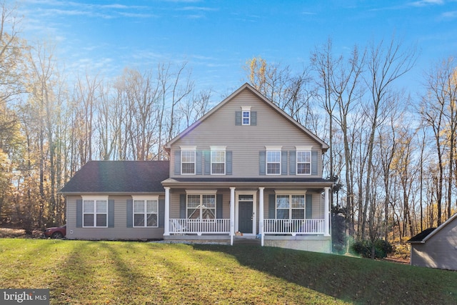 front facade featuring covered porch and a front yard