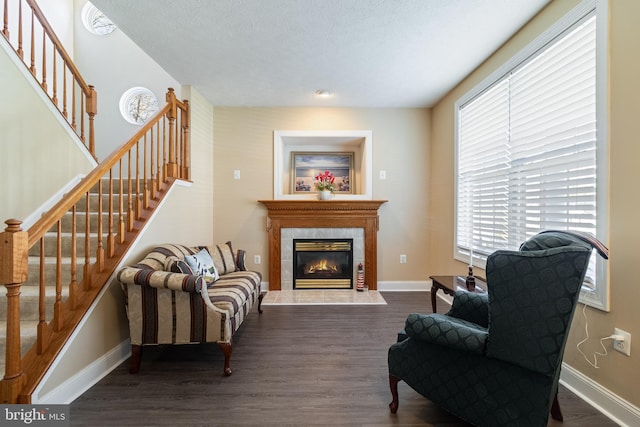 living area with a textured ceiling, dark hardwood / wood-style flooring, and a fireplace