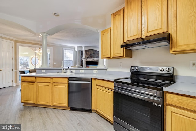 kitchen with ornate columns, sink, stainless steel appliances, an inviting chandelier, and light hardwood / wood-style floors