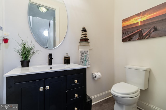 bathroom with vanity, wood-type flooring, and toilet