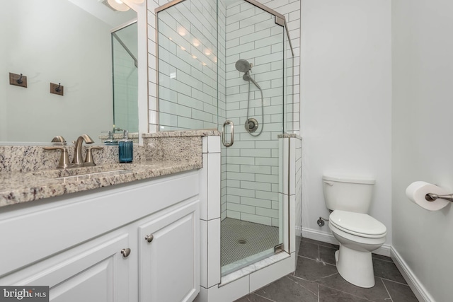 bathroom featuring vanity, tile patterned flooring, toilet, and walk in shower