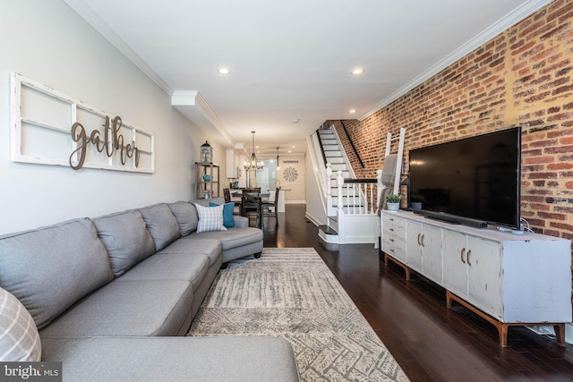 living room with ornamental molding, a chandelier, brick wall, and dark hardwood / wood-style flooring