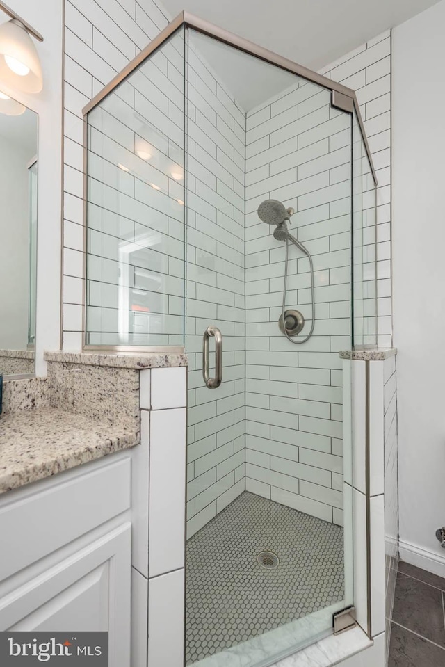 bathroom with vanity, a shower with shower door, and tile patterned floors