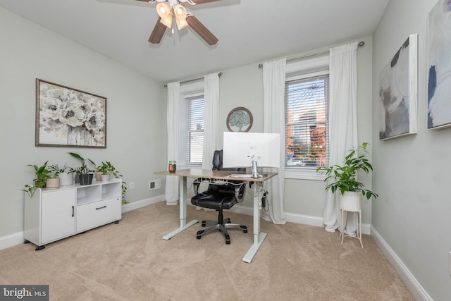 carpeted office space featuring ceiling fan