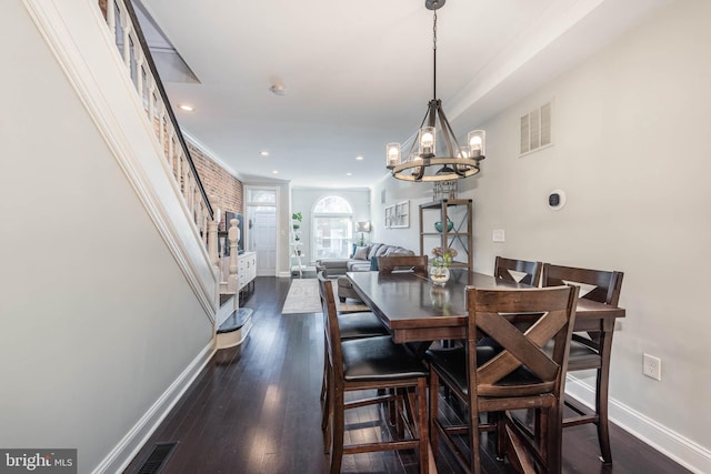 dining space featuring dark wood-type flooring and an inviting chandelier