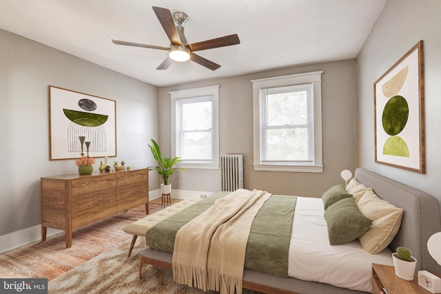 bedroom featuring hardwood / wood-style floors, radiator, and ceiling fan