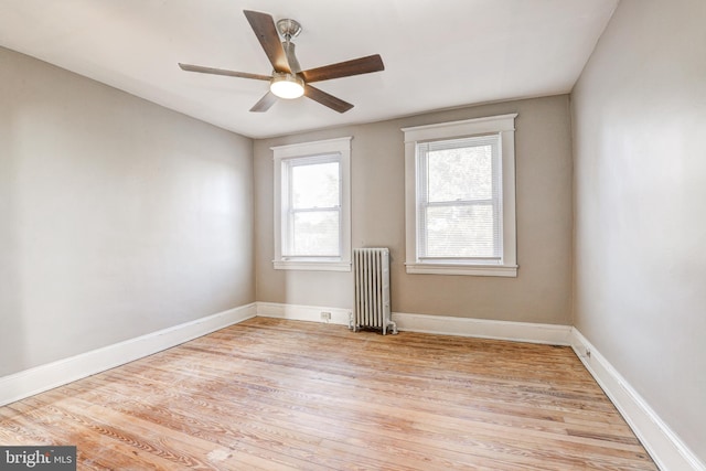 unfurnished room featuring light hardwood / wood-style flooring, ceiling fan, and radiator