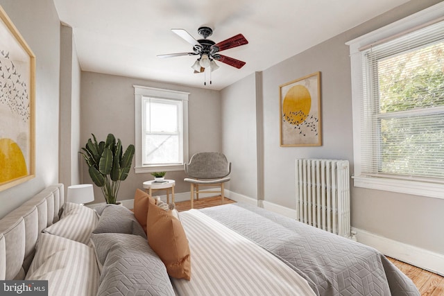 bedroom featuring ceiling fan, hardwood / wood-style flooring, and radiator heating unit