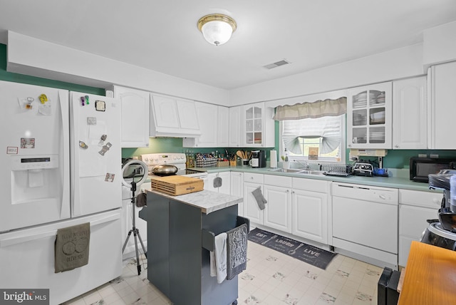 kitchen with white cabinetry, white appliances, sink, and custom range hood